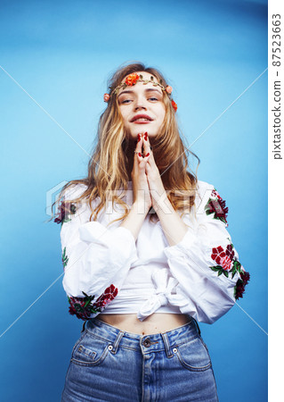 young pretty blond girl posing on blue background, fashion style hippie boho flowers on head young pretty blond girl posing on blue background, fashion style hippie boho flowers on head 87523663
