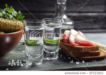 Cold Russian vodka with snacks on wooden table Cold Russian vodka with snacks on wooden table 87523841