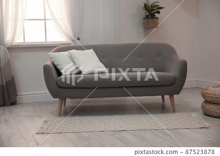Modern comfortable sofa in stylish home interior Modern comfortable sofa in stylish home interior 87523878