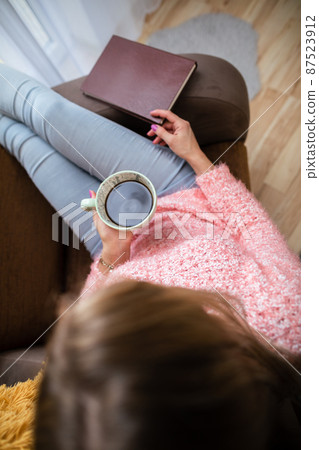 View from above as a girl holds a cup of coffee. View from above as a girl holds a cup of coffee. 87523912