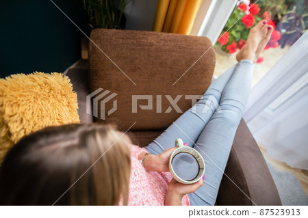 View from above as a girl holds a cup of coffee. View from above as a girl holds a cup of coffee. 87523913
