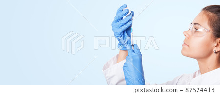 Doctor holding a syringe with vaccine against corona virus. 87524413