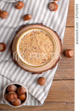 Raw Organic Ground Hazelnut Flour in a Bowl with whole nuts on rustic wooden background. Alternative nut flour Raw Organic Ground Hazelnut Flour in a Bowl with whole nuts on rustic wooden background. Alternative nut flour 87524845