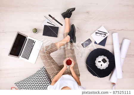 Fashion blogger with laptop sitting on floor, top view 87525111