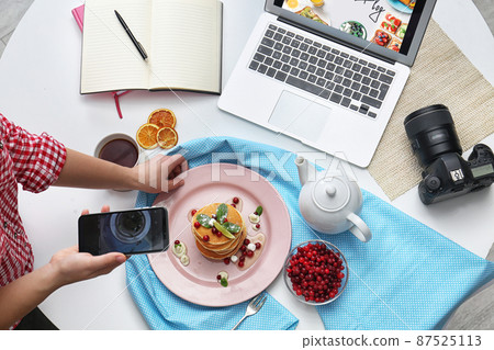 Food blogger taking photo of her breakfast at table, top view 87525113