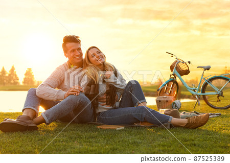 Happy young couple spending time together on picnic outdoors Happy young couple spending time together on picnic outdoors 87525389