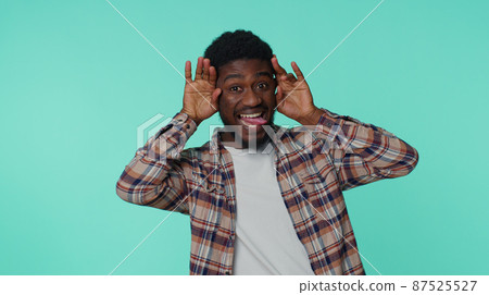 Funny happy man making playful silly facial expressions, grimacing, fooling around showing tongue Funny happy man making playful silly facial expressions, grimacing, fooling around showing tongue 87525527