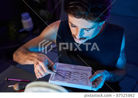 Caucasian man taking lushes from the box while making gorgeous make up Caucasian man taking lushes from the box while making gorgeous make up 87525862