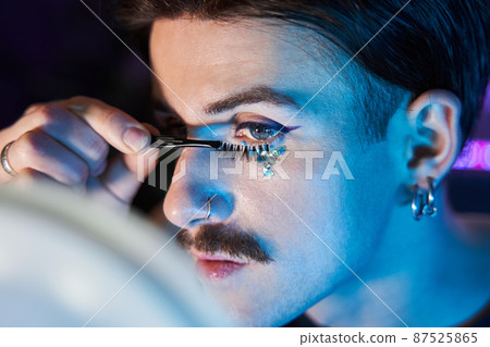 Man likes to bring beauty to his face, doing make-up, applying lushes Man likes to bring beauty to his face, doing make-up, applying lushes 87525865
