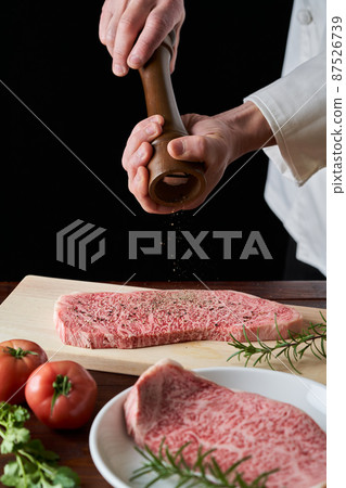 Domestic Wagyu beef loin steak A cook who sprinkles pepper on meat 87526739