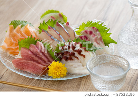 生魚片和清酒放在玻璃板上 87528196