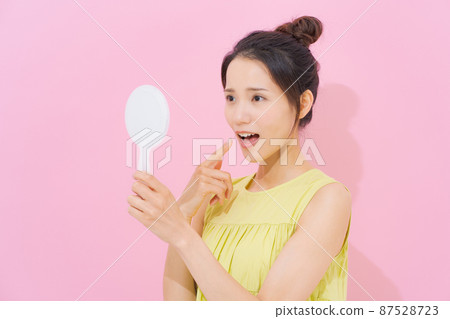 看著鏡子粉紅色背景的女人 看著鏡子粉紅色背景的女人 87528723