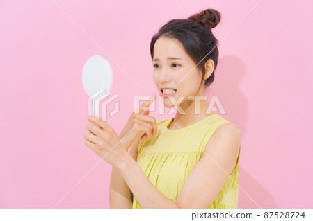 看著鏡子粉紅色背景的女人 87528724