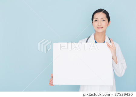 Female doctor with whiteboard Female doctor with whiteboard 87529420