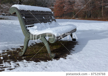 Park bench on a snowy day 87529788