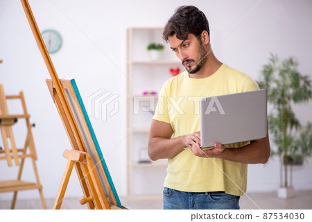 Young man enjoying painting at home 87534030