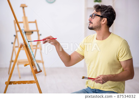 Young man enjoying painting at home 87534032