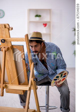 Young man enjoying painting at the studio Young man enjoying painting at the studio 87534039