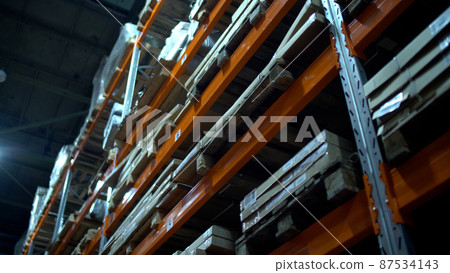 Rows of shelves with Goods in Cardboard Boxes and Packages full of in retail warehouse. Logistics, Sorting and Distribution Facility for Product Delivery. 87534143