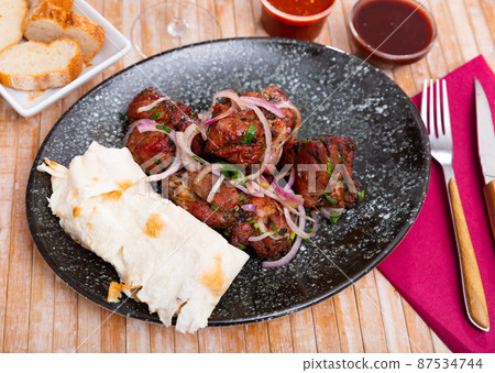 Grilled pork meat shashlik with marinated onion Grilled pork meat shashlik with marinated onion 87534744