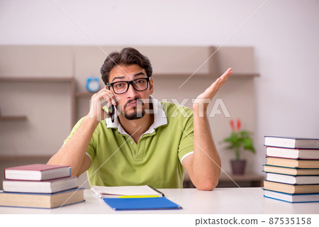 Young male student studying at home 87535158