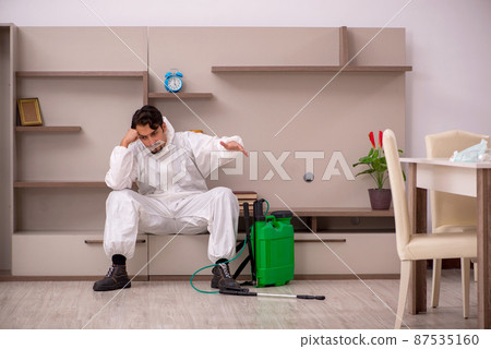 Young male contractor doing pest control at home Young male contractor doing pest control at home 87535160