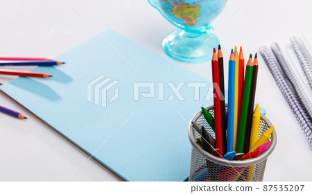 Various color pencils and notebooks on a wooden table Various color pencils and notebooks on a wooden table 87535207