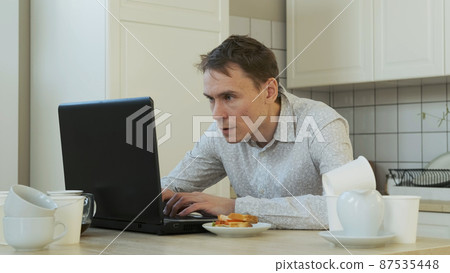 Tired Male Freelancer Overwhelmed with Job, Using Laptop All Night Long. Drinking from Coffee Pot. Working Overtime, Remote Work and Freelancer Lifestyle Concept Tired Male Freelancer Overwhelmed with Job, Using Laptop All Night Long. Drinking from Coffee Pot. Working Overtime, Remote Work and Freelancer Lifestyle Concept 87535448