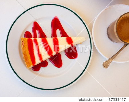 Classic cheesecake served with sweet berry sauce 87535457