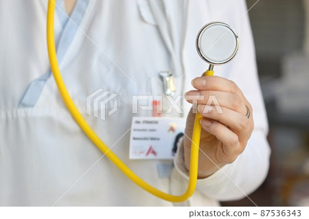 Female doctor holding a stethoscope. Concept for health and medicine. Hospital background. 87536343