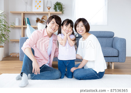Family portrait A smiling family sitting on the living room floor 87536365