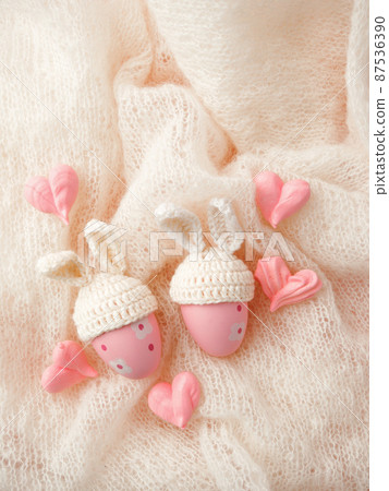 Happy Easter holiday concept with cute handmade eggs, knitted bunny hats and sweet pink decor, copy space. Greeting card, banner for your site, flyer, banner, invitation, discount card 87536390