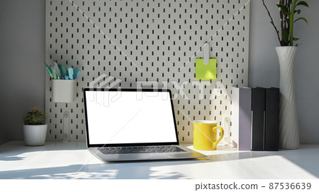 Modern workplace with laptop computer, coffee cup, houseplant and stationery on white table. Modern workplace with laptop computer, coffee cup, houseplant and stationery on white table. 87536639