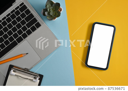Creative workplace with smart phone, computer laptop and succulent plants on colorful background. Creative workplace with smart phone, computer laptop and succulent plants on colorful background. 87536671