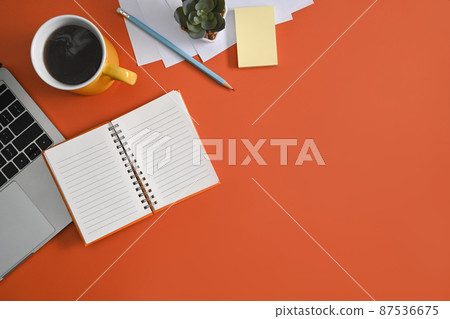 Notebook, laptop computer and coffee cup on orange background. Top view. 87536675
