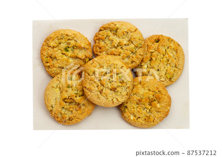 Pistachio and almond cookies on brown paper on white background. Pistachio and almond cookies on brown paper on white background. 87537212