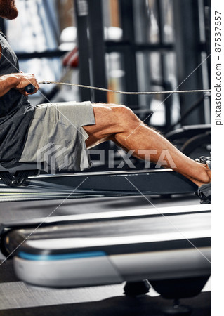 Training legs in the simulator, the athlete works with his legs on the simulator, working out the muscles on the legs Training legs in the simulator, the athlete works with his legs on the simulator, working out the muscles on the legs 87537857