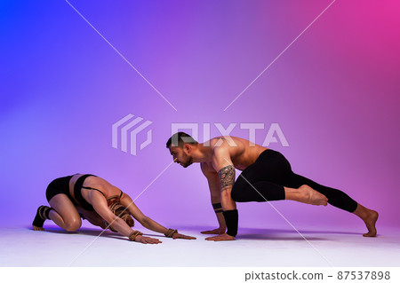 Beautiful young acrobats or gymnasts with colorful face painting on pink blue gradient background. Professional ballet couple dancing, Emotional duet performing choreographic art. Animal instinct Beautiful young acrobats or gymnasts with colorful face painting on pink blue gradient background. Professional ballet couple dancing, Emotional duet performing choreographic art. Animal instinct 87537898