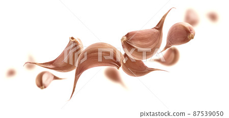 Garlic cloves levitate on a white background Garlic cloves levitate on a white background 87539050
