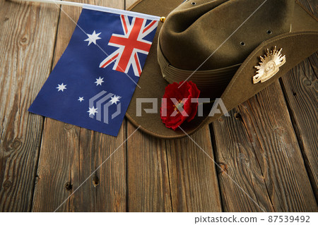 Anzac army slouch hat with Australian Flag and Poppy on wooden background 87539492