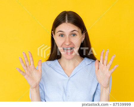 Scary emotion. Gesturing woman. Frighten situation. Screaming shocked lady holding hands up expressing stunning feelings isolated yellow. Scary emotion. Gesturing woman. Frighten situation. Screaming shocked lady holding hands up expressing stunning feelings isolated yellow. 87539999