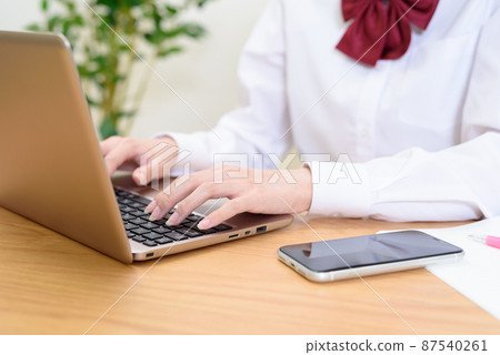 高中女生一邊在筆記本電腦上打字一邊學習 觀看視頻 在線課程 87540261