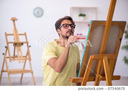 Young man enjoying painting at home 87540670