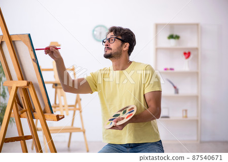 Young man enjoying painting at home 87540671