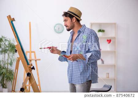 Young man enjoying painting at the studio 87540672