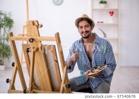 Young man enjoying painting at the studio Young man enjoying painting at the studio 87540676