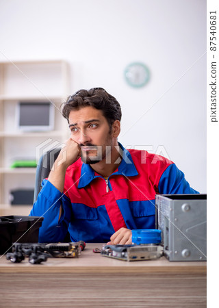Young male repairman repairing computer Young male repairman repairing computer 87540681