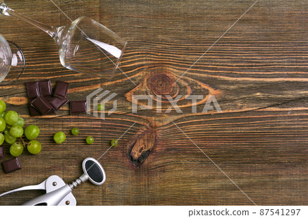 Glasses of wine and ripe grapes isolated on a wooden table Glasses of wine and ripe grapes isolated on a wooden table 87541297