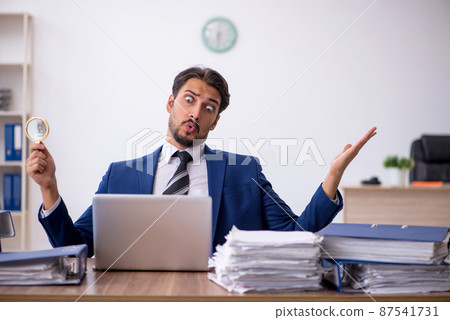 Young male employee and too much work in the office 87541731