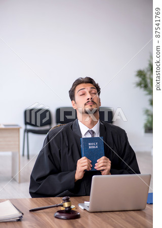 Young male judge taking oath on holly bible 87541769